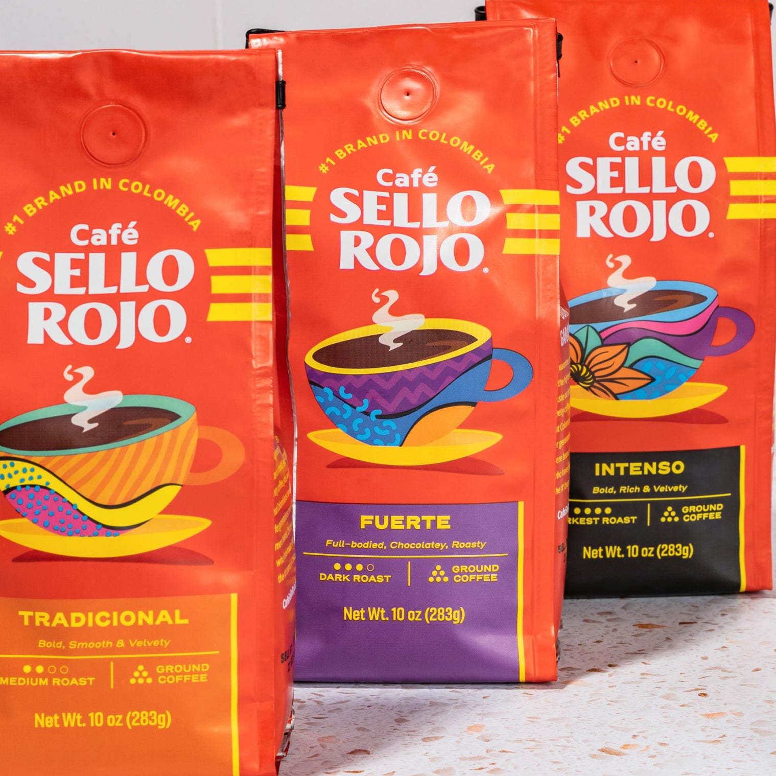 Three bags of Cafe Sello Rojo coffee on a light surface